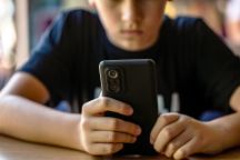 Problem of children's addiction to gadgets, online, screen time. Child, teenager or preteen mobile phone. Mobile addiction, digital dependence concept. Child boy with cell phone, holds smartphone