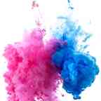 Pink and blue clouds of paint underwater flowing in an artistic, abstract pattern.