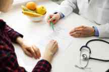 Dietitian consultation with a male practitioner and patient discussing a diet plan.