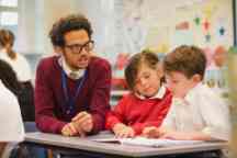 Schoolboys Work with their Teacher in Elementary Class