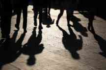 Black silhouettes and shadows of people on the street
