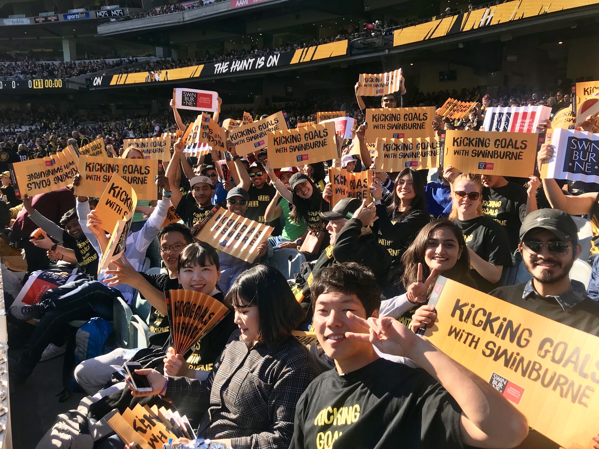 International students at Richmond vs St Kilda game Swinburne students socialising watching the AFL at the MCG