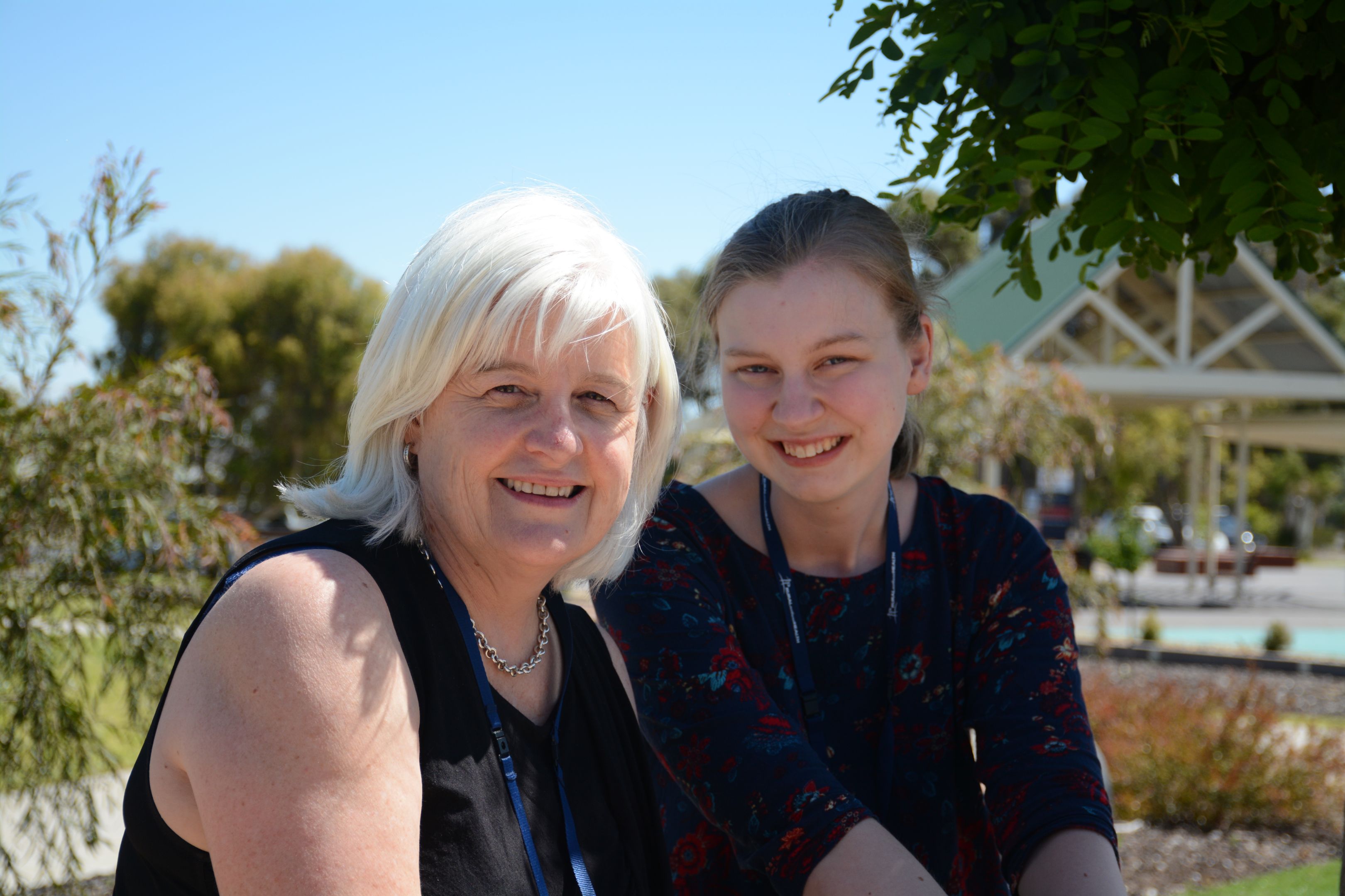 Rural Northwest Health Photograph of Dr Kaye Knight of Rural Northwest Health with a professional placement student. Both women are wearing black and sitting outdoors with trees behind them.