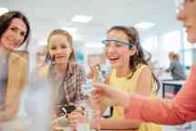 A group of young students working on a science project with the help of their teacher.