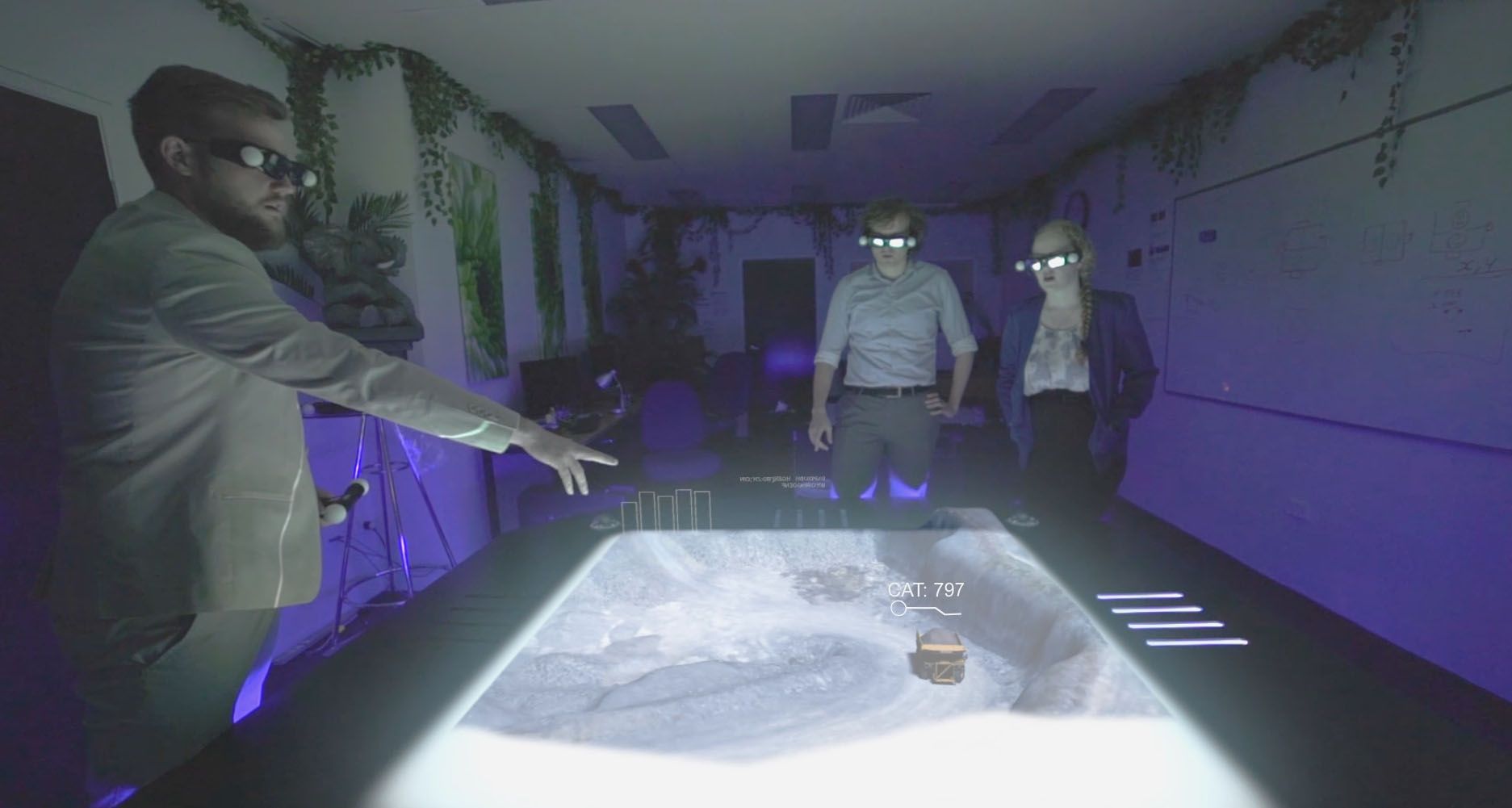 Hologram table - Construction Simulation Hub Two people with 3D glasses and wands stand around a holgram table projecting a 3D image of a city