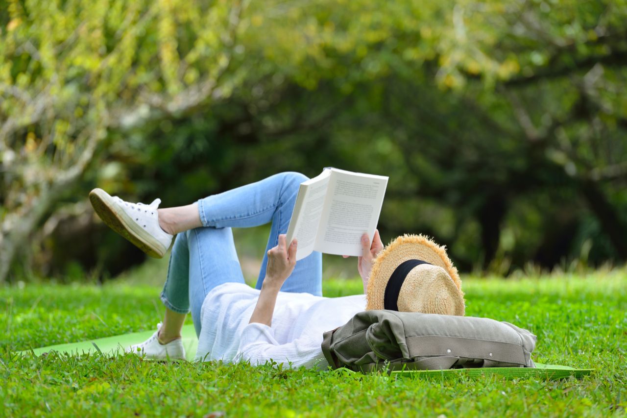 STOCK-Woman_lying_on_green_grass_reading_a_book Woman lying on green grass reading a book