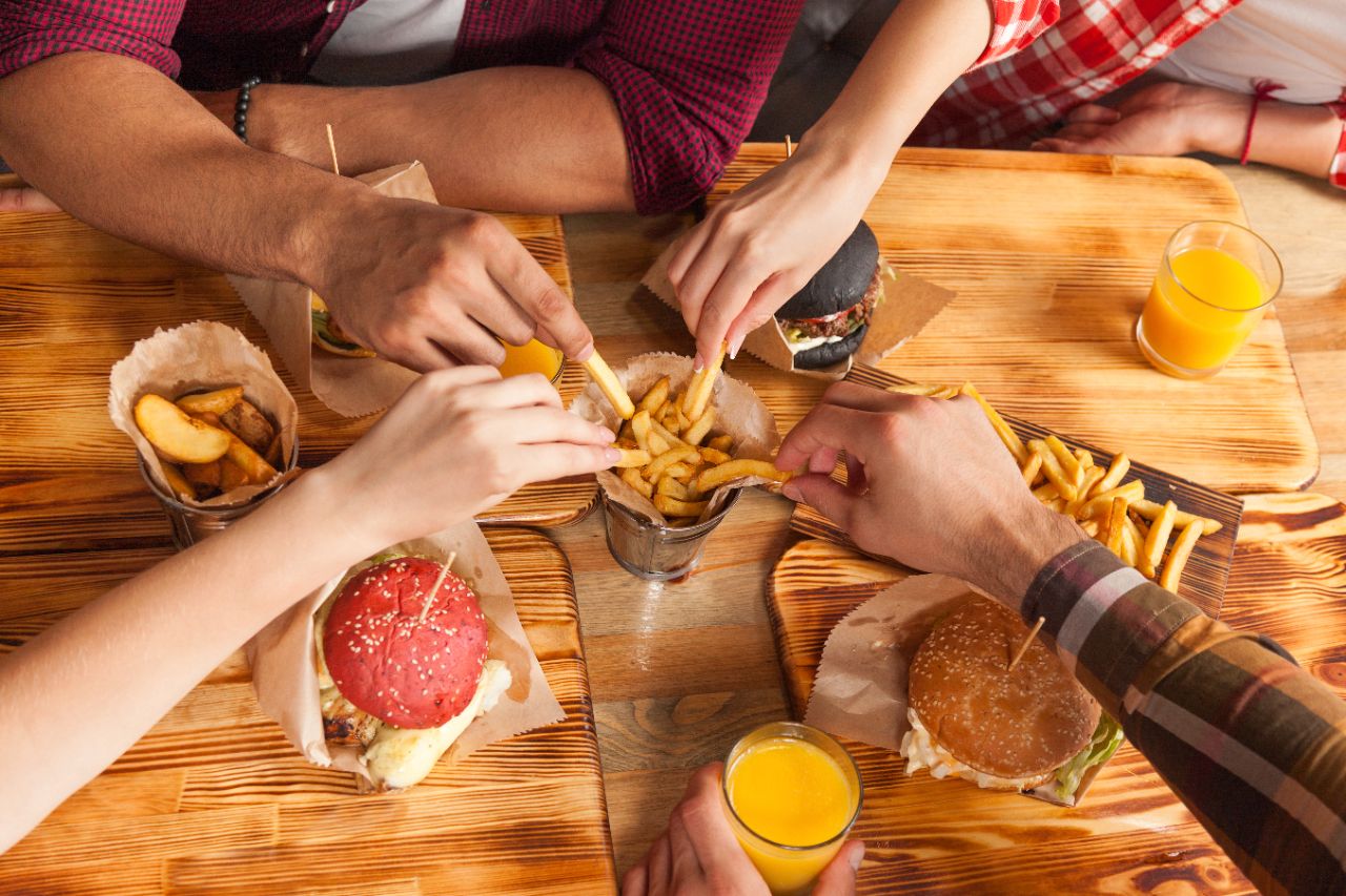 STOCK_group_eating_fast_food People Group Friends Hands Eating Fast Food Burgers Potato Drinking