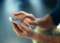 Male hands typing on smartphone.