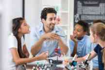 Friendly teacher engages students during biology lab