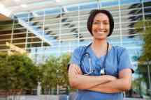 Smiling mixed race female healthcare worker outside hospital