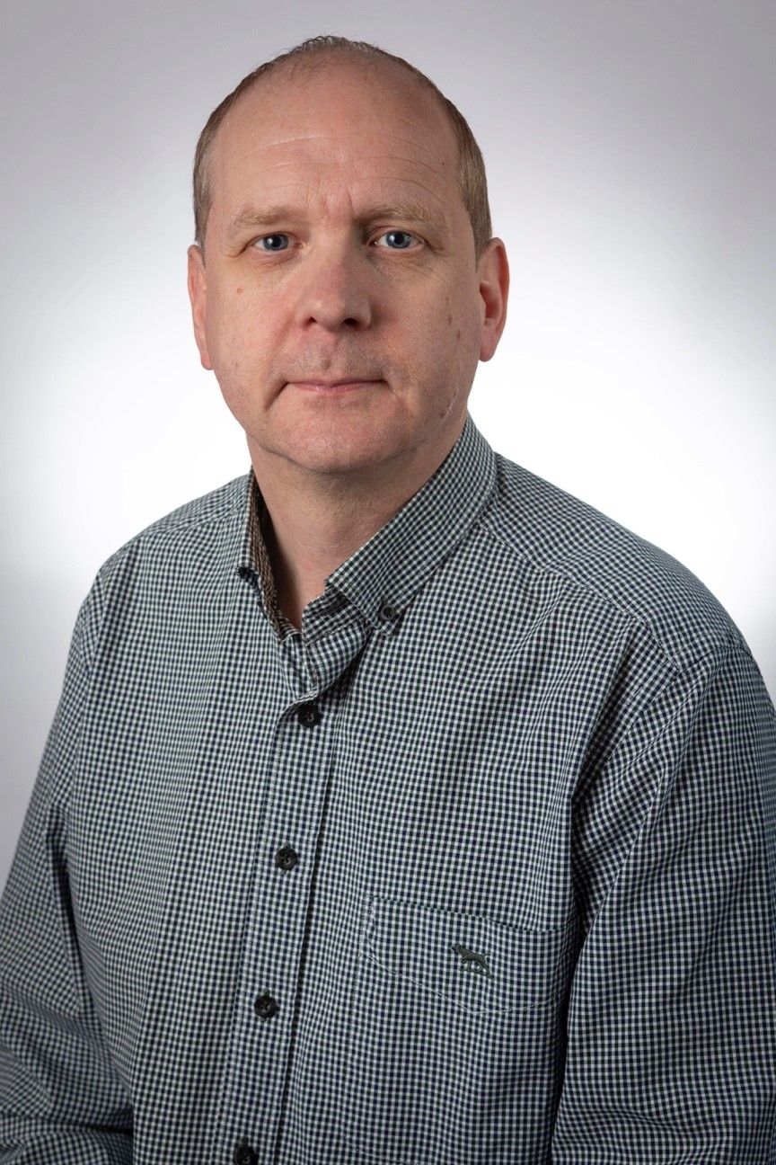 Associate Professor Andrew Carroll Headshot of Andrew Carroll wearing a green chequered shirt