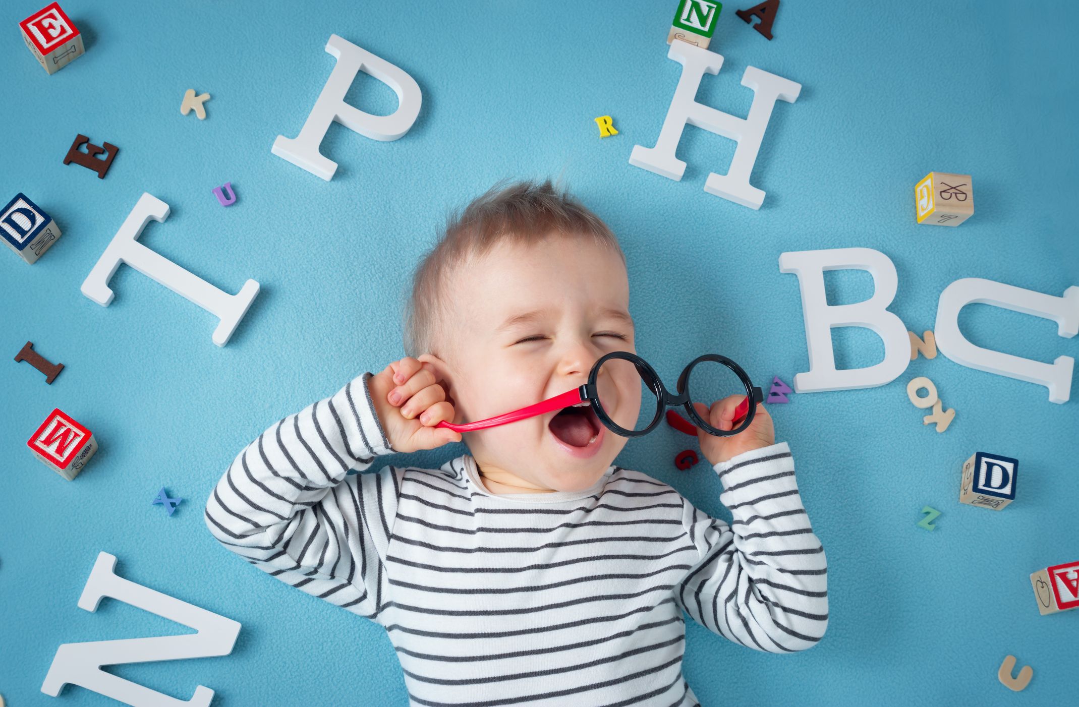STOCK Infant Spectacles One year old child lying with spectacles and letters