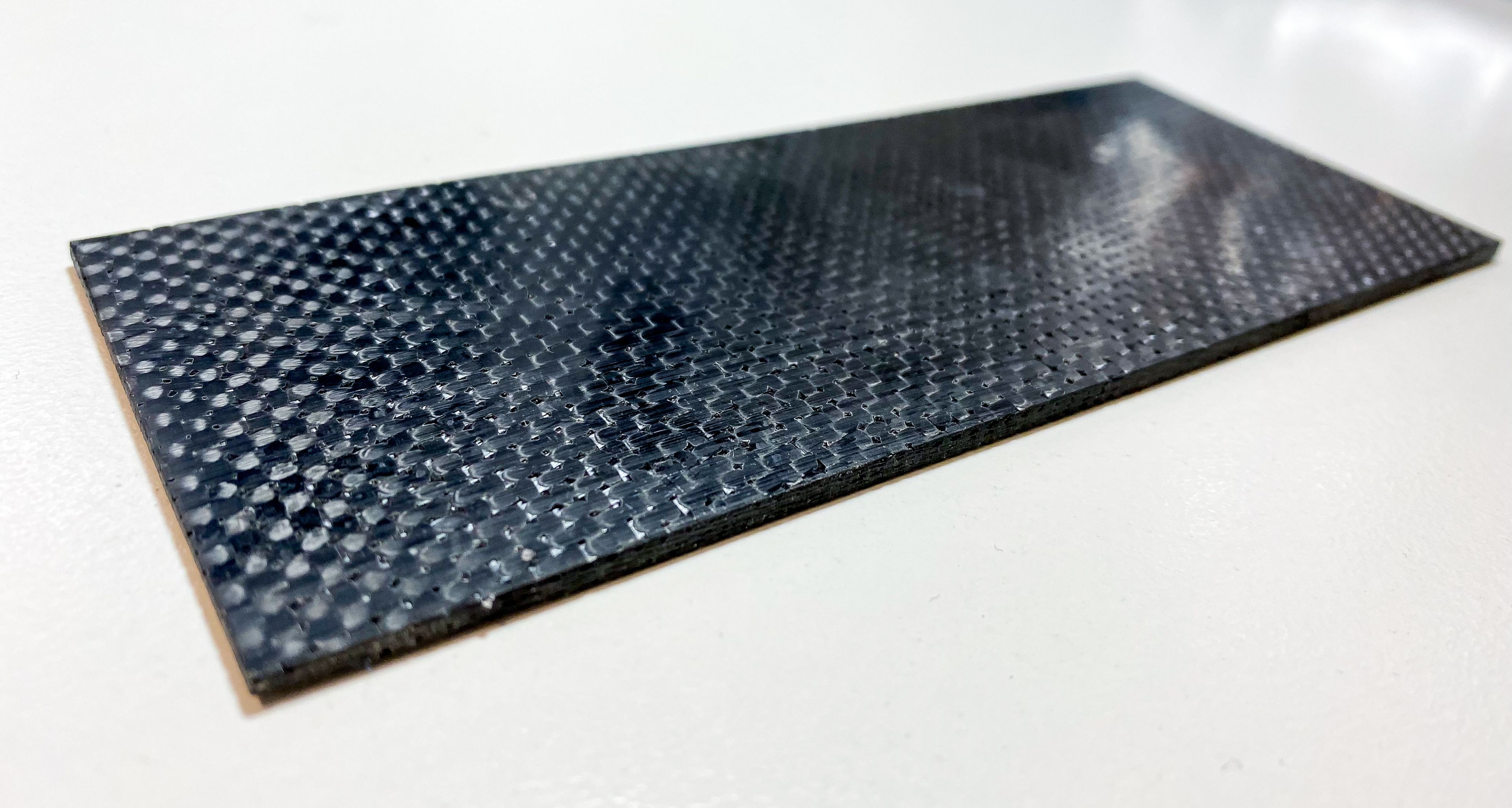 Smart graphene composite A black reflective graphene material on a white desk