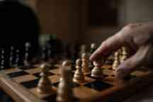 Chess board and human hand close up