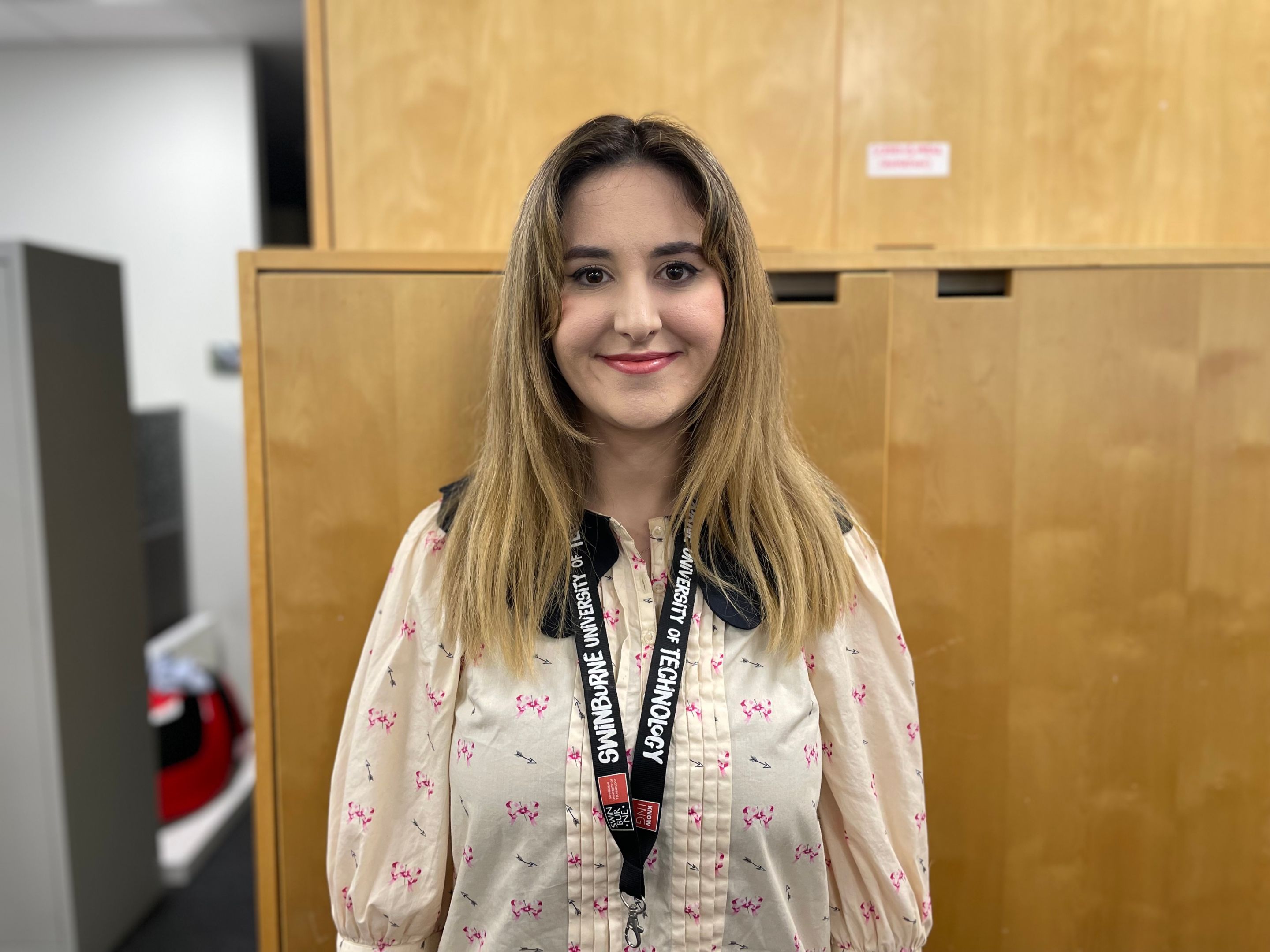 Andriana Pipingas - student success coach Woman standing face to camera smiling wearing a blouse and lanyard