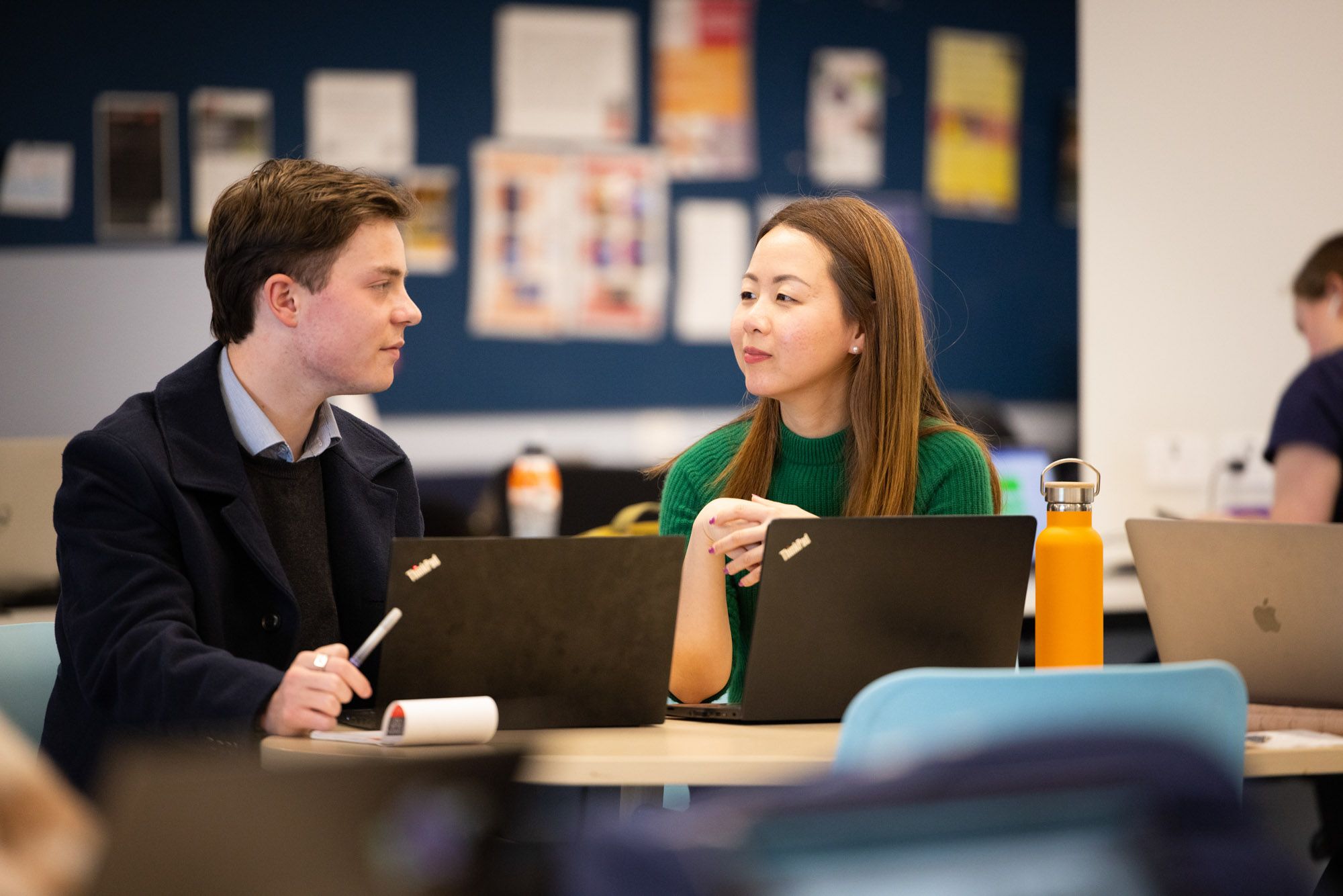 Wei-Li-with-student.jpg A woman in green is teaching a younger student
