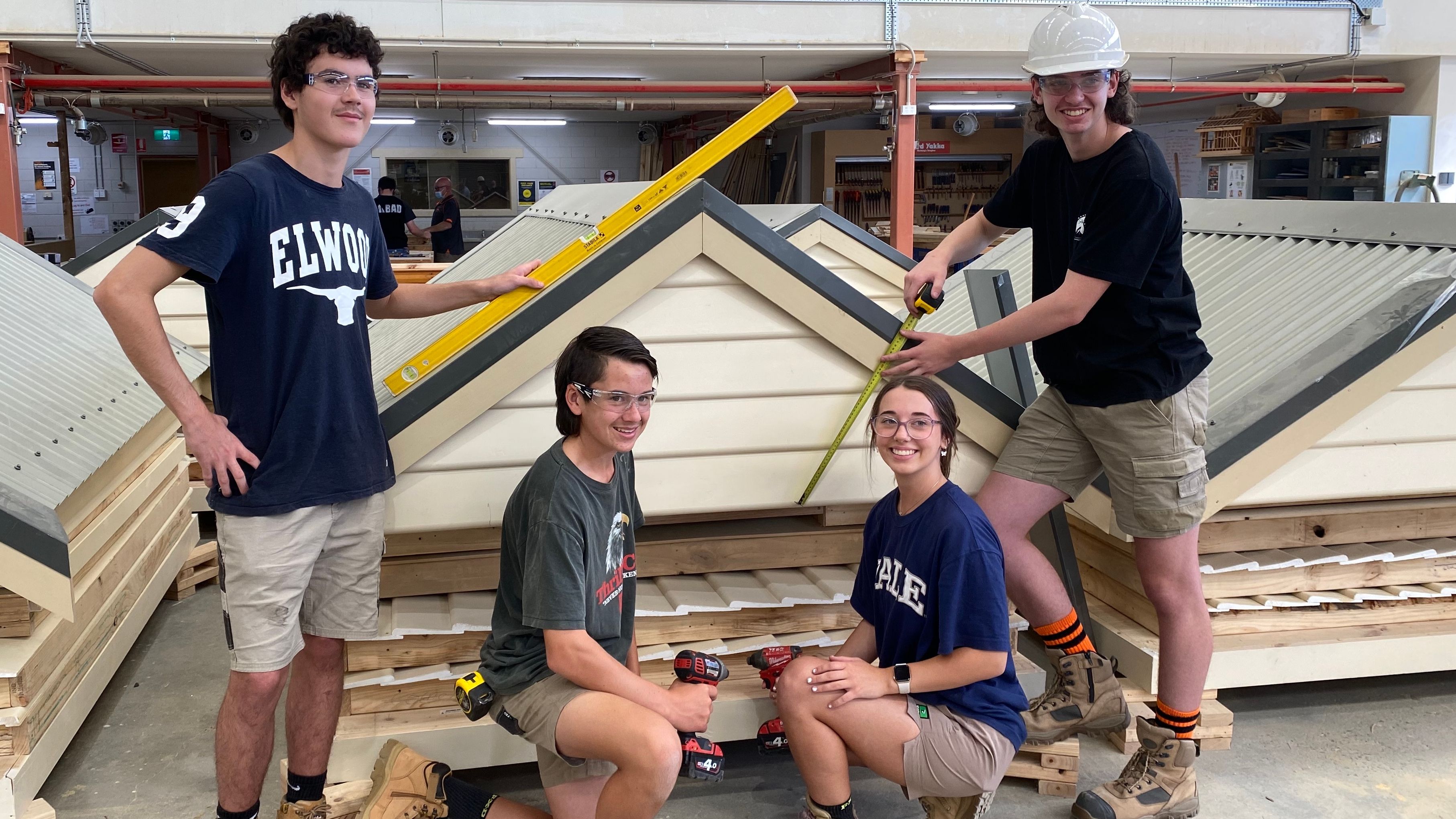 Croydon VET students tool sheds Vet Studnets holding tools and building equipment in front of tool sheds built for bushfire affected communities