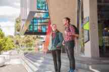 two male students stand outside a building in Hawthorn campus with backpacks
