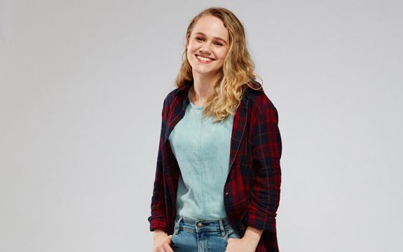 Placement student Deborah A smiling female student with wavy blonde hair and her hands in her jean pockets.