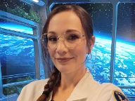 A female student in a Swinburne lab coat in front of a space background of earth 