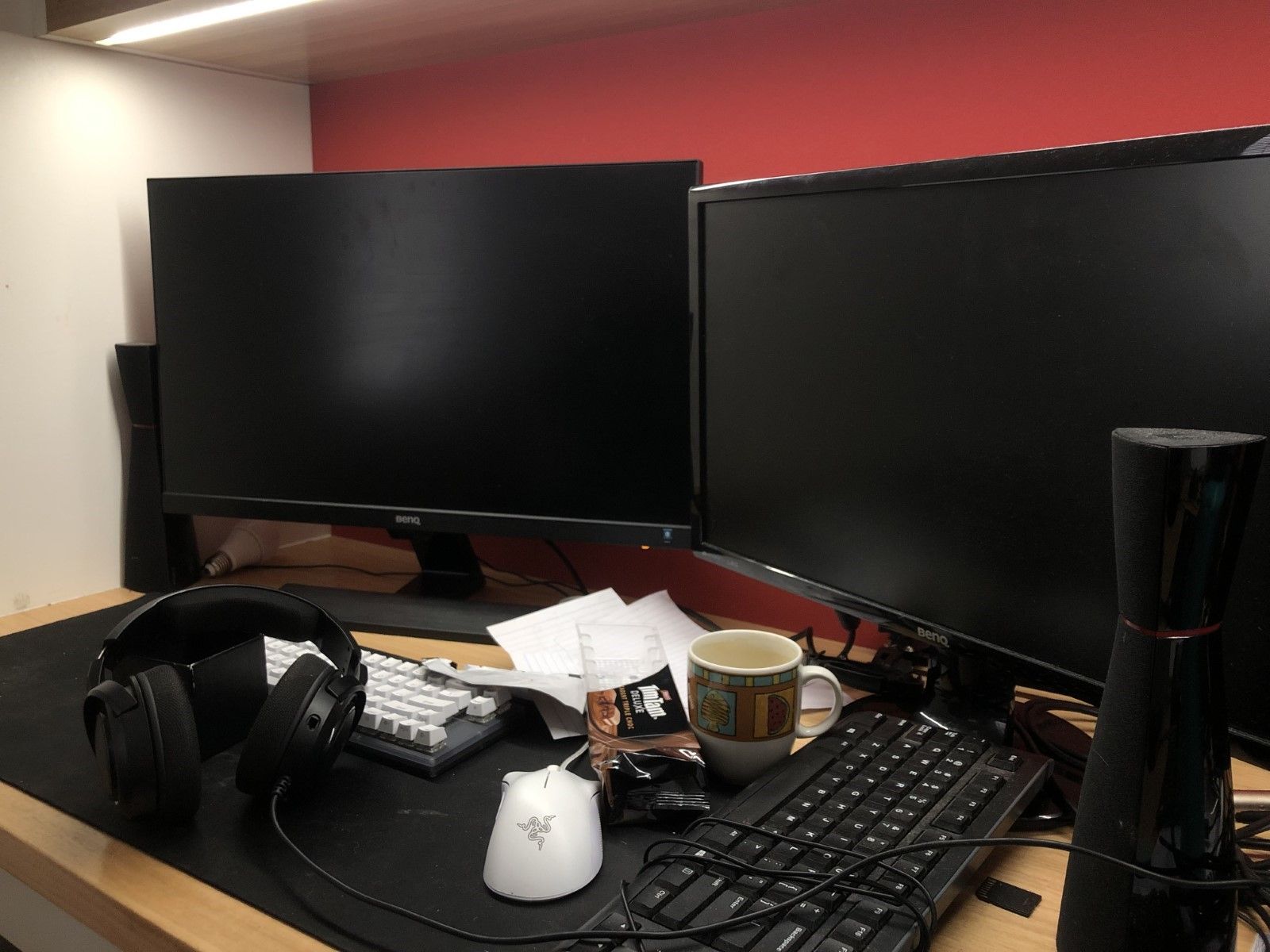Lewis prefers a study space where he can immerse himself in his work. Lewis’s desk, complete with two large computer monitors, over-ear headphones, a half-eaten packet of Tim Tams and an empty coffee mug.