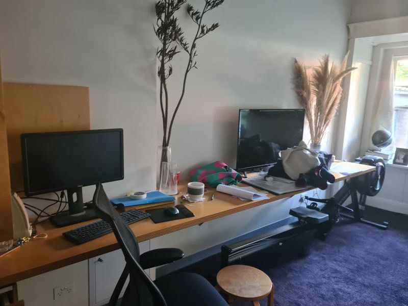 Poppy has a family of desk co-owners to contend with while studying. Poppy’s shared desk in her family home with two computers, a pile of clothes, various stationery and a rowing machine tucked underneath.