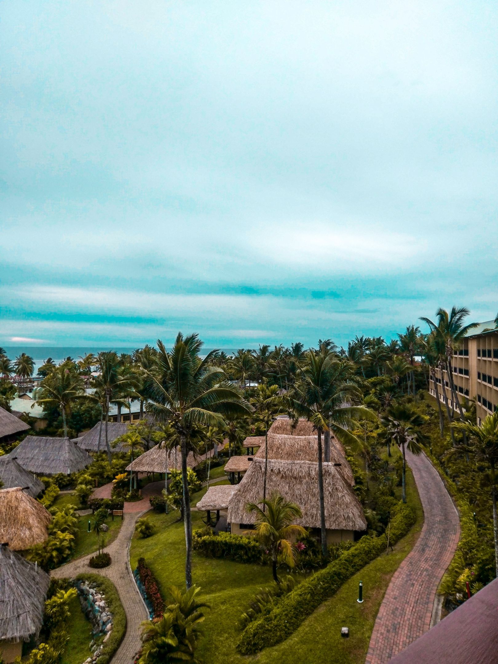 Fiji Traditional huts, luscious landscaping and views to a bright blue sea