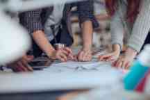A group of design students gathered around a project