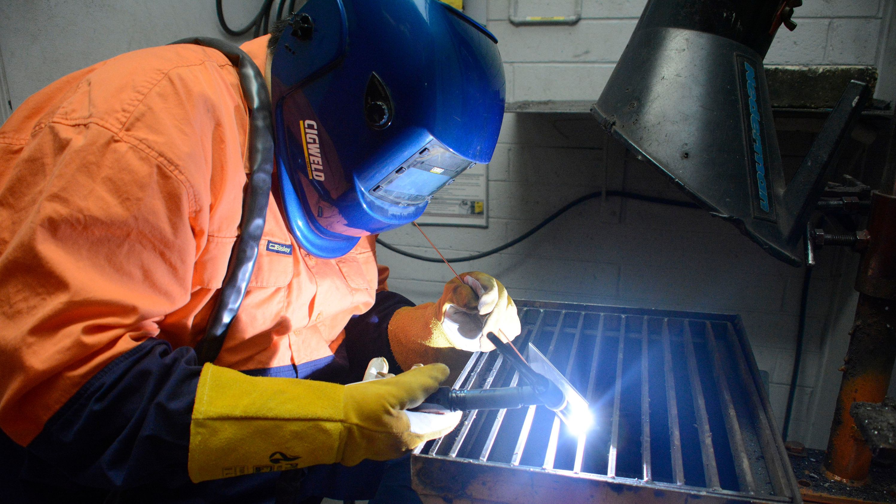 Swinburne student at work during their basic introduction to welding short course. Swinburne student operating welding soldering equipment whilst wearing protective gloves and gear. Swinburne students operating welding soldering equipment whilst wearing protective gloves and head gear..